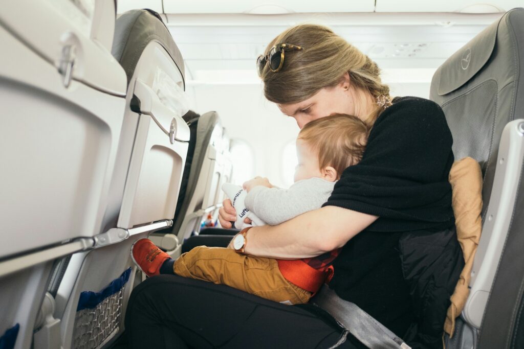 A woman carrying a baby on a plane