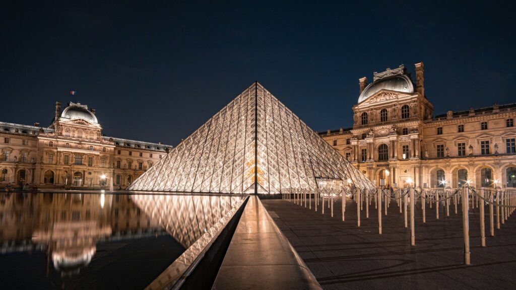 The Louvre's glass pyramid lit up against the night sky