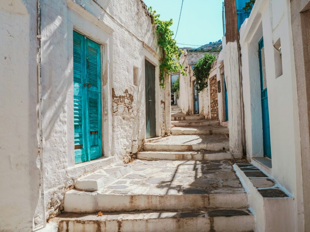 A quiet painted alley with white stones and blue doors